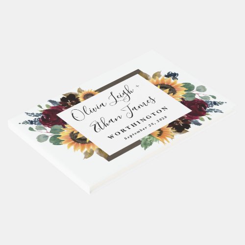 Sunflower and Roses Burgundy Red Navy Blue Wedding Guest Book - Design features elegant watercolor roses, peonies, wildflowers and sunflowers in various shades of burgundy red, navy blue and more over a wreath of eucalyptus greenery. Design also features a barn wood frame underneath the wreath. A unique font layout compliments the overall design. You can change the background color on the front and back to the color of your choice or leave both set to white. View the collection on this page to find matching wedding stationery products.