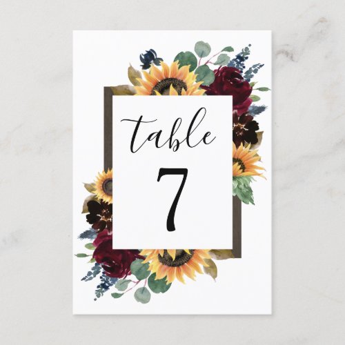 Sunflower Roses Burgundy Navy Wedding Table Number - Design features elegant watercolor roses, peonies, wildflowers and sunflowers in various shades of burgundy red, navy blue and more over a wreath of eucalyptus greenery. Design also features a barn wood frame underneath the wreath. A unique font layout compliments the overall design. You can change the background color on the front and back to the color of your choice or leave both set to white. View the collection on this page to find matching wedding stationery products.