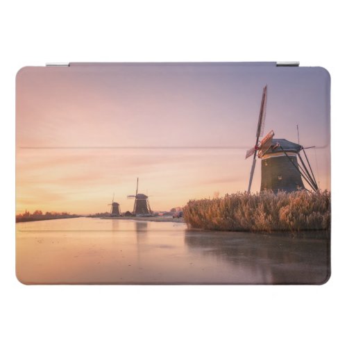 Sunrise over frozen river with windmills and reeds iPad pro cover