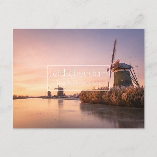 Sunrise over frozen river with windmills and reeds postcard