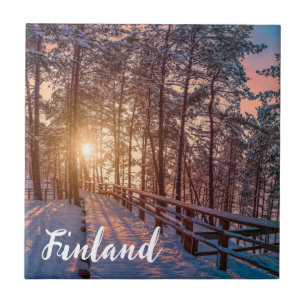 Sunset in snowy pine forest with sun ray ceramic tile