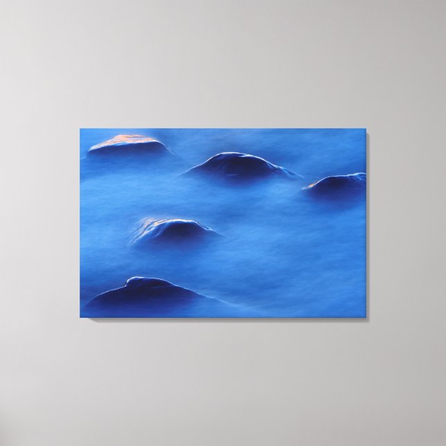 Sunset on rocks protruding through foamy water canvas print (Front)