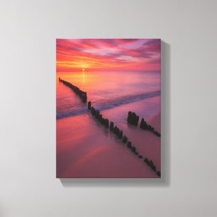 Sunset Over Beach with Wooden Posts Canvas Print