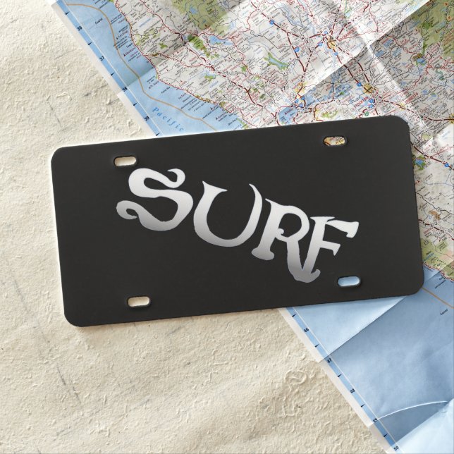 Surf tilted black plastic car license plate (In Situ)