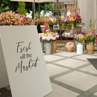 An airy outdoor display styled with farmers’ market charm—fresh florals, produce signage, and handwritten accents. Pastel tones and soft greenery create a cheerful, artisanal vibe. The layout feels intimate and organic. It evokes seasonal freshness and playful femininity.