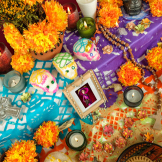A vibrant ofrenda with marigolds, candles, colorful papel picado, and framed portraits, styled in warm lighting. The tone is celebratory and reverent, honoring tradition with joyful color.
