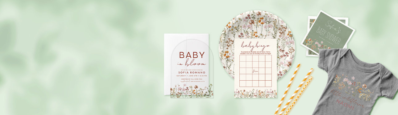 Soft wildflower baby shower collection with sage green and floral accents, including invitation, party plate, bingo game card, and personalized baby onesie.