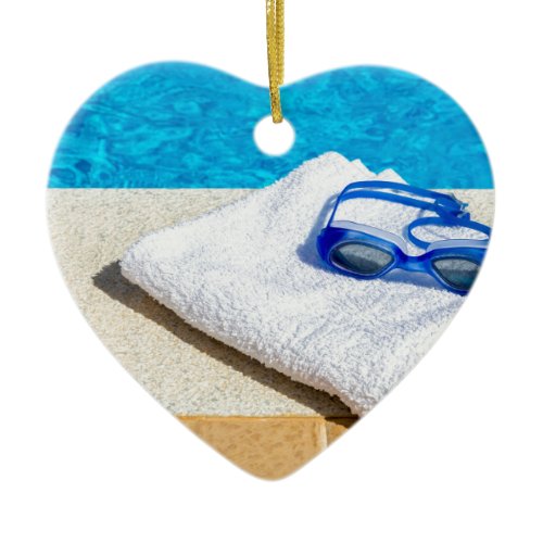 Swimming goggles and towel near swimming pool ceramic ornament