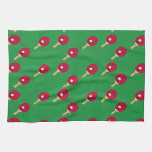 Table tennis racket and ball on green kitchen towel
