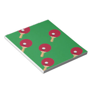 Table tennis racket and ball on green notepad