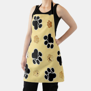 Tan and black paw print on a gold background apron