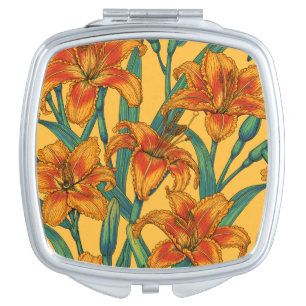 Tawny daylily flowers, blue and yellow compact mirror