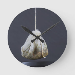 Tea bag is hung in a cup round clock