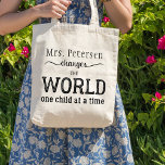 Teacher name black typography script quote tote bag<br><div class="desc">Personalized "YOUR TEACHER (name) changes the world one child at a time" thoughtful typography quote in black and white. Make it a thoughtful keepsake thank you gift for your teacher!</div>