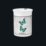 Teal Butterfly Floral Beverage Pitcher<br><div class="desc">Serve your hot or cold beverages with this unique Teal Butterfly Floral Personalized Porcelain Pitcher. Pitcher design features a pair of vibrant butterflies resting on a white floral vine against a light gray grunge background. Additional gift items available with this design as well as a variety of colors.</div>