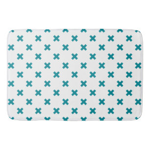 Teal cross stitches on white bath mat
