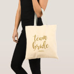 Team Bride Gold Glitter Bridesmaid Bachelorette Tote Bag<br><div class="desc">An elegant cutting edge design,  features the text "Team Bride" in a extroverted script font,  the glitter texture adds a festive and glamorous touch. You can personalize the background color according to your needs and preferences,  please contact me if you have any special request.</div>