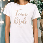 Team Bride Wedding Personalized Beige White T-Shirt<br><div class="desc">Celebrate your bride squad with this personalized wedding t-shirt! The words 'Team Bride' are written in a trendy script font, and below you can add a custom name, wedding date, location or other text. A lovely gift for a bachelorette party, wedding shower or celebration weekend! Colors: natural beige and white....</div>