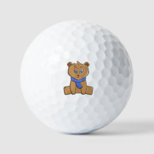 Teddy bear wearing a blue scarf golf balls