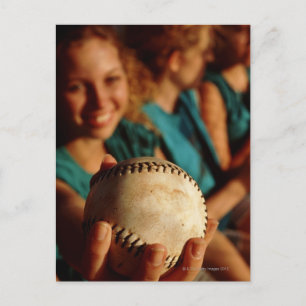 Teenage girls' softball team sitting in dugout postcard