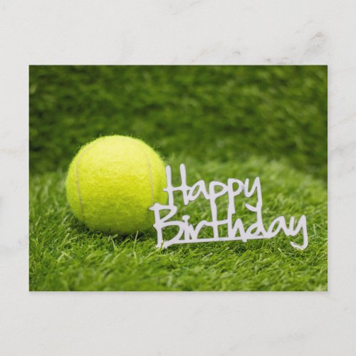 Tennis ball and happy birthday word on green grass postcard