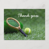 Tennis ball and racket on green grass postcard