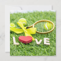 Tennis ball and racket on green grass with love