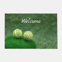 Tennis ball are on green grass doormat