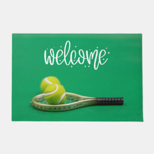 Tennis ball are on green grass welcome  doormat