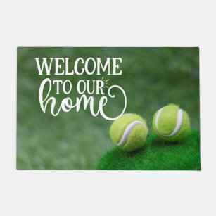 Tennis ball are on green grass welcome doormat