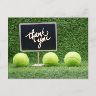 Tennis ball is on green grass with chalkboard than postcard
