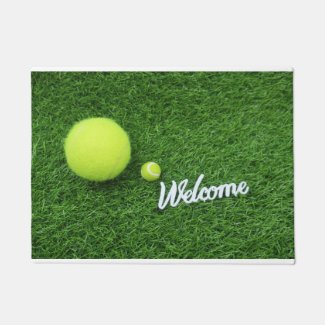 Tennis balls are on green grass welcome Bath Mat