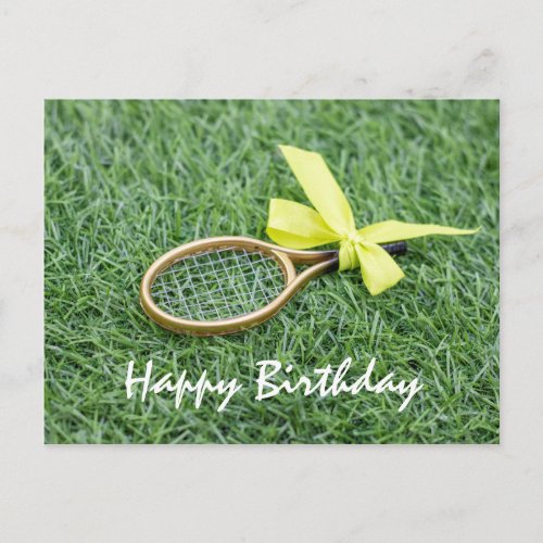 Tennis racket and tennis balls are on green grass postcard