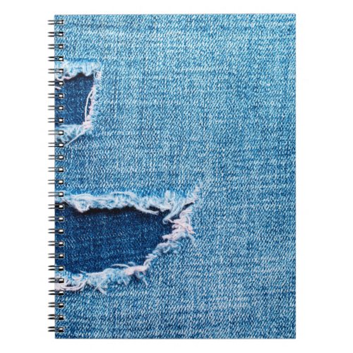 Textured denim background Torn hole in the fabric Notebook