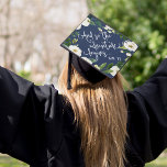 The Adventure Begins | Custom Class Year Graduation Cap Topper<br><div class="desc">Beautiful grad cap topper features the quote "And so the adventure begins" in white script lettering on a navy blue background adorned with white watercolor flowers and green foliage. Personalize with your class year and/or school.</div>