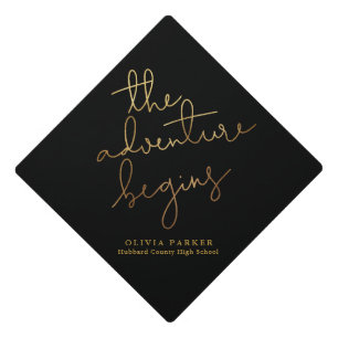 the adventure begins gold black typography graduation cap topper