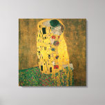 The Kiss by Gustav Klimt Canvas Print<br><div class="desc">The Kiss (Lovers) was painted by the Austrian Symbolist painter Gustav Klimt between 1908 and 1909, the highpoint of his "Golden Period", when he painted a number of works in a similar gilded style. A perfect square, the canvas depicts a couple embracing, their bodies entwined in elaborate robes decorated in...</div>