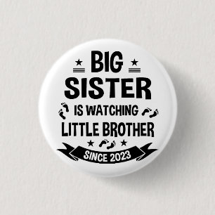 The little sister takes care of the big brother in button