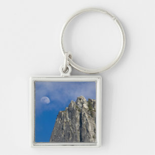 The moon rises and shines through the clouds keychain