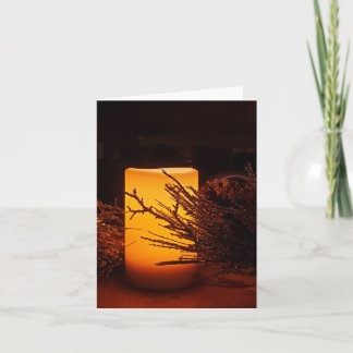 The soft glow of a holiday candle in the darkness  card