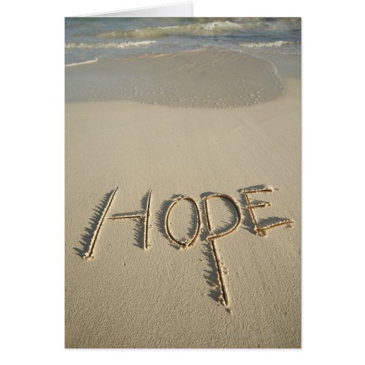 The word 'Hope' sand written on the beach with (Front)