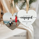 The Year We Got Engaged Names & Photo Ceramic Ornament<br><div class="desc">Personalized engagement Christmas ornament with custom photo, a meaningful keepsake for couples celebrating the year they got engaged. The heart-shaped ornament features the phrase “The Year We Got Engaged” in elegant script paired with classic serif text for names and the year, creating a timeless and romantic look. The minimalist black...</div>