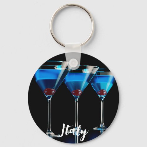 Three blue cocktails with cherry on black keychain