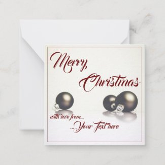 Three christmas balls in front of light background note card