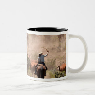 Three cowboys and cowgirls driving cattle Two-Tone coffee mug