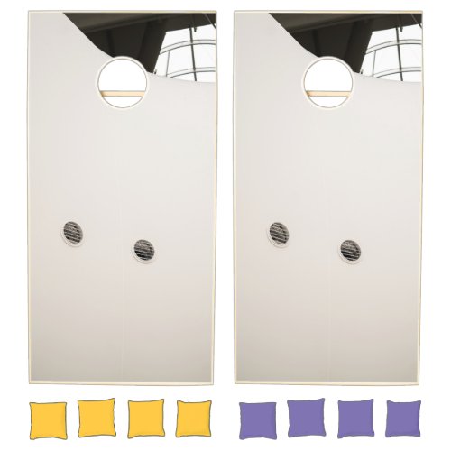 Three round holes in the side of a building cornhole set