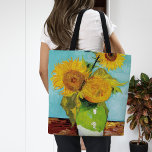 Three Sunflowers | Vincent van Gogh Tote Bag<br><div class="desc">Three Sunflowers (1888) by Vincent van Gogh is a vibrant still life that showcases the artist’s signature thick brushstrokes and bold use of color. The painting features three sunflowers in a simple vase, their golden petals contrasting against the aqua blue background. Van Gogh's vivid yellow palette brings energy and life...</div>