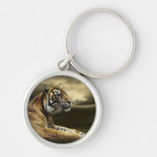 Tiger looking and sitting under dramatic sky keychain