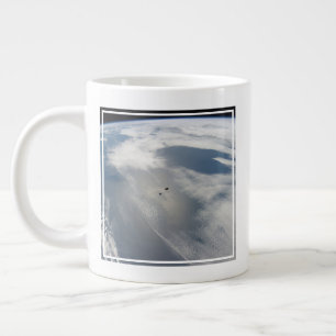 Tiny Satellites Orbit Above A Part Of Earth. Giant Coffee Mug