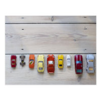 Toy cars lined up in a row on floor postcard